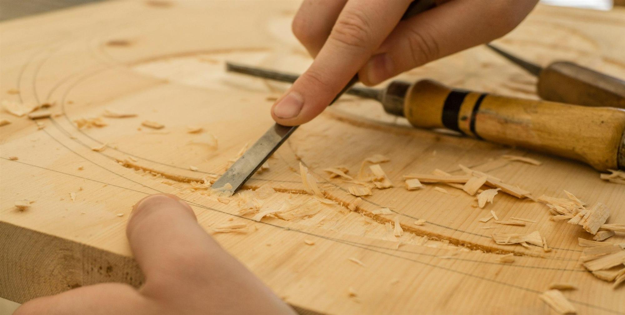 A craftsman shaping wood with a chisel